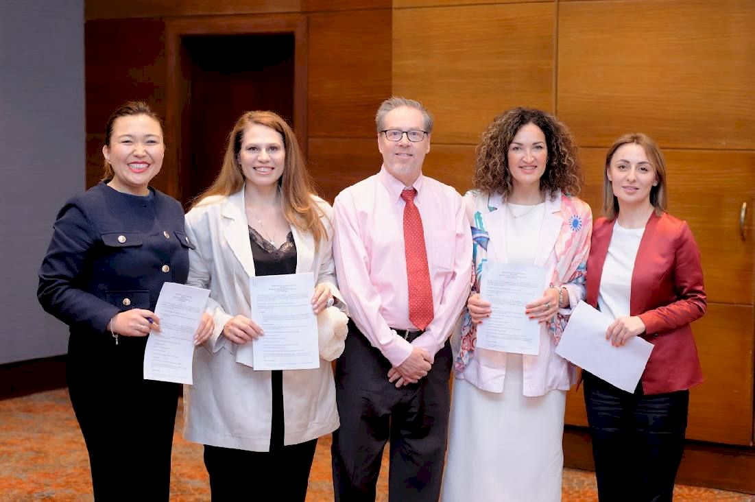 Signatories standing behind a table after signing